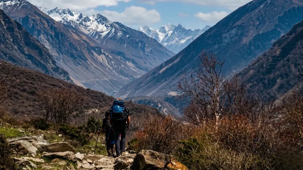 Traditional Buddhist chortens in the Manaslu Circuit Trek region with eroded cliffs and Himalayan mountains.